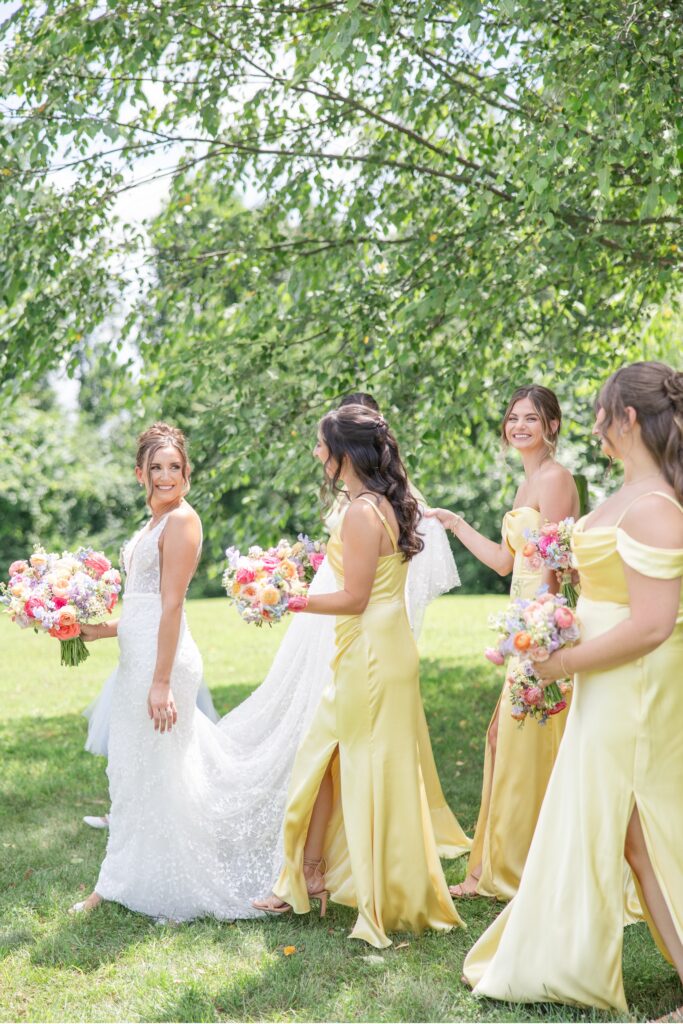 Cleveland Wedding Photographer Bride and Bridesmaids walking together with colorful florals summer wedding
