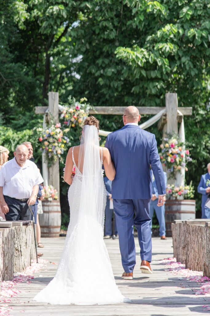 Outdoor wedding ceremony at Enchanted Acres Wedding Venue Bride and Dad walking down the aisle