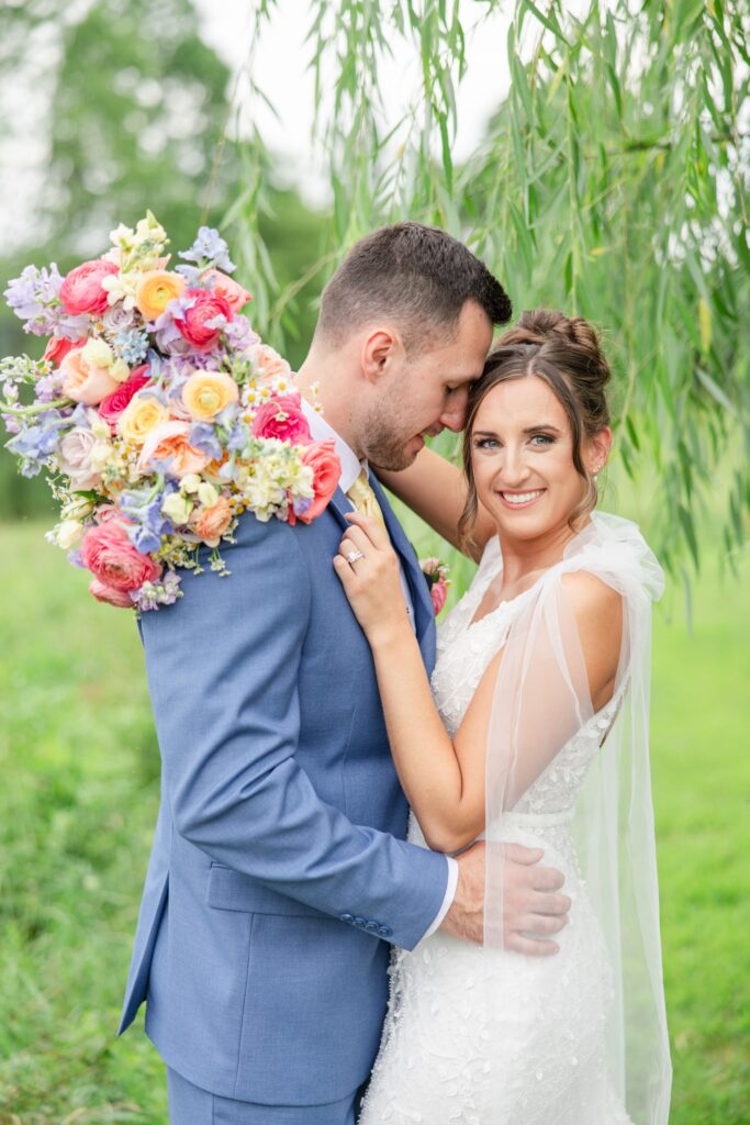 Classic Summer wedding in Cleveland Wedding Photographer; bride and groom embracing with colorful bouquet