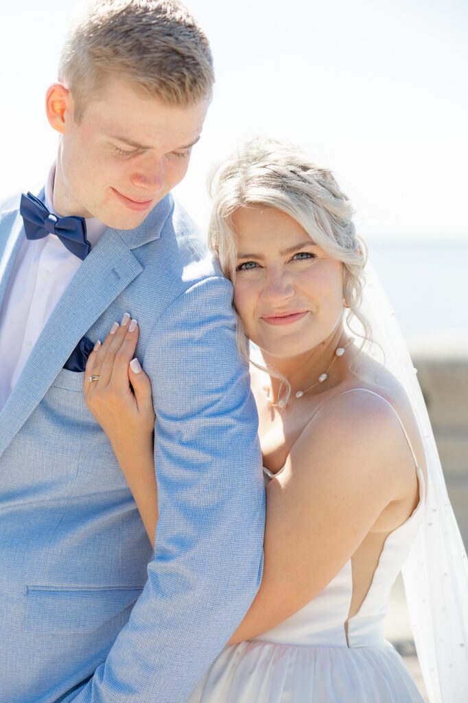 Cleveland waterfront wedding photo location bride and groom snuggling close in the sunshine at E 9th St. Pier